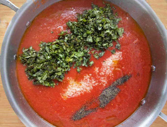 crushed tomatoes and seasonings in a large pot to make spaghetti sauce