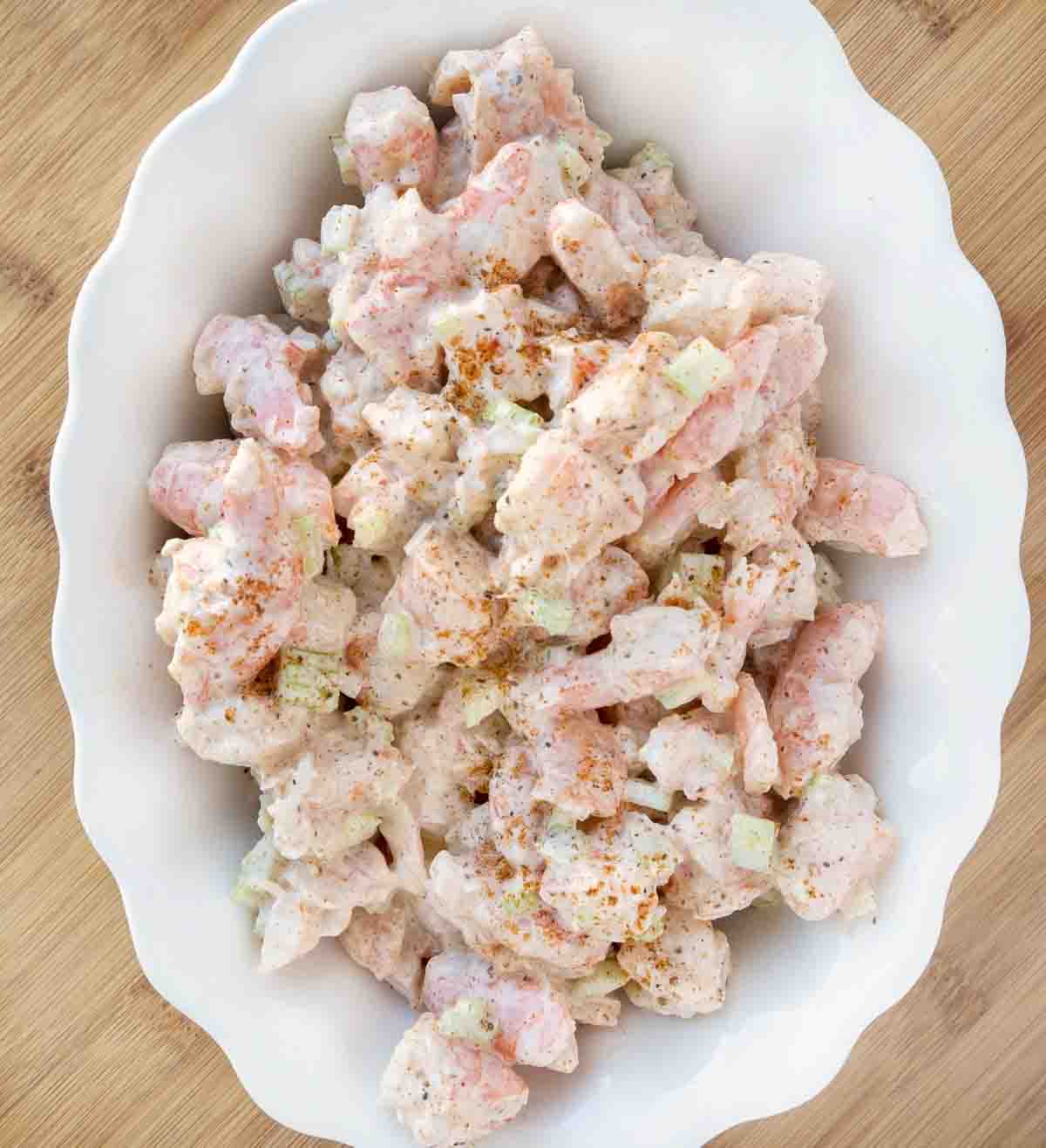 overhead shot of shrimp salad in a white scalloped edge bowl