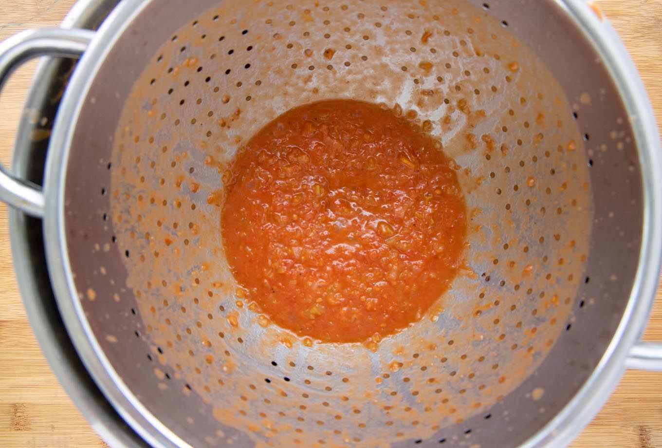 strainer holding bits of celery, onion and tomato that weren't pureed