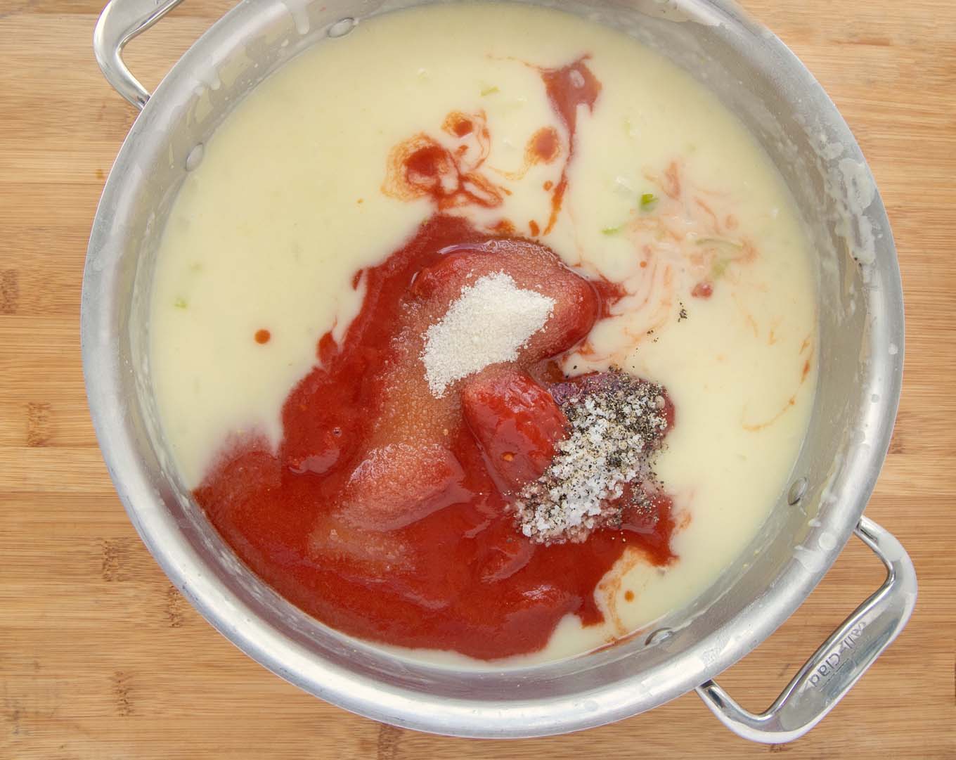 Veloute with tomatoes and seasonings in a large pot.