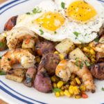 sunny side up eggs on top of the shrimp and potato combination