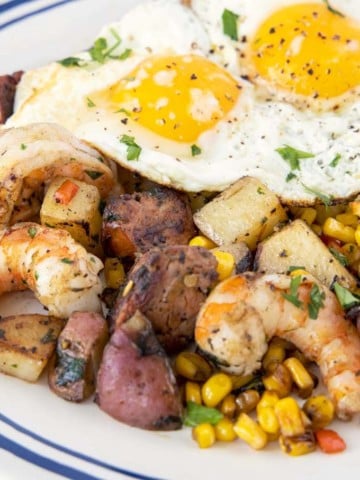 sunny side up eggs on top of the shrimp and potato combination