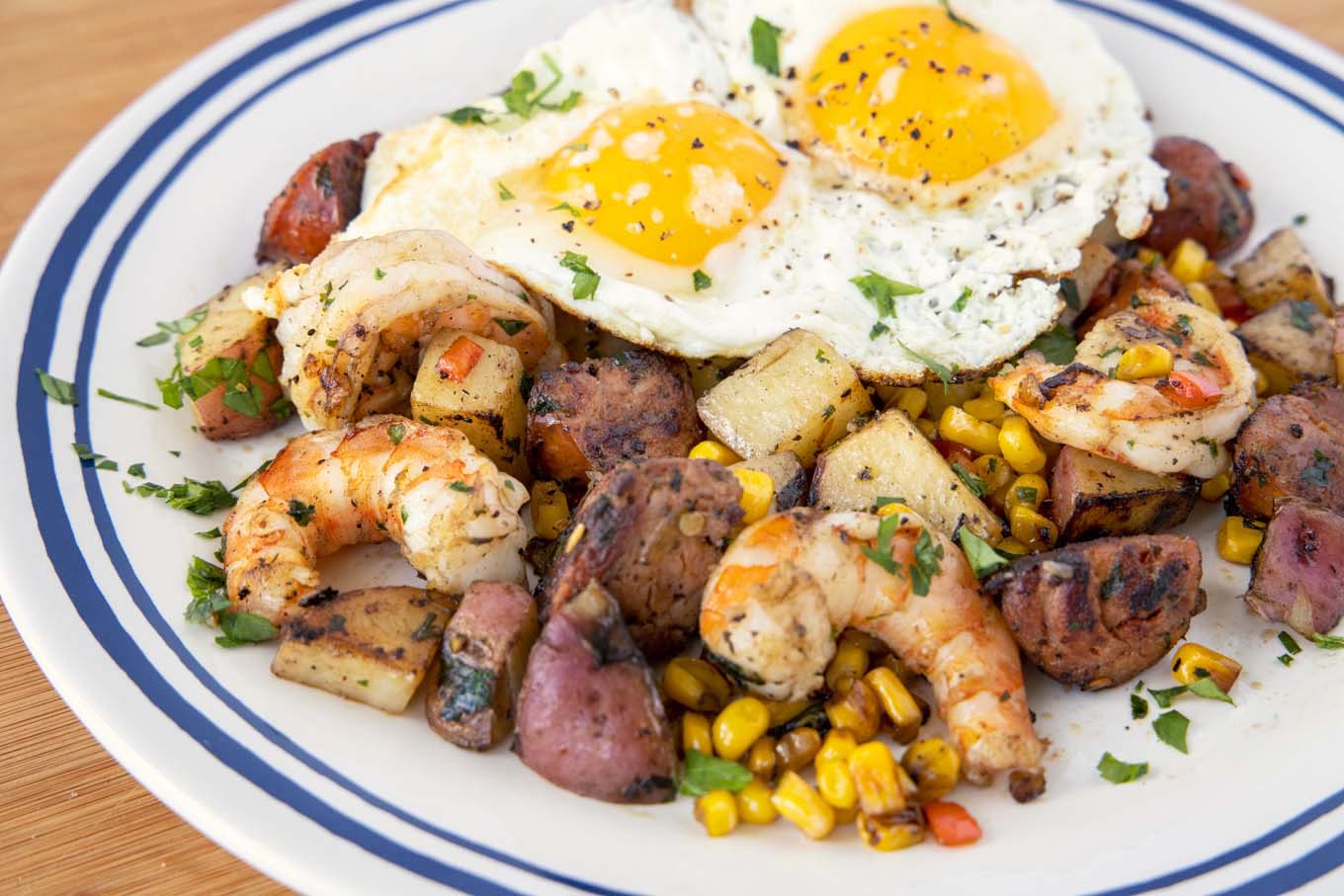 sunny side up eggs on top of the shrimp and potato combination