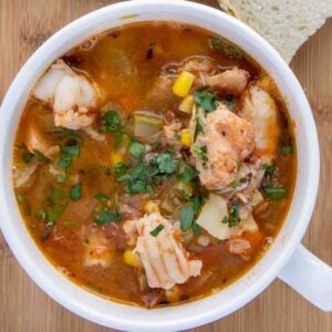 Seafood soup in a white cup.