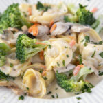 tortellini and broccoli in a white bowl