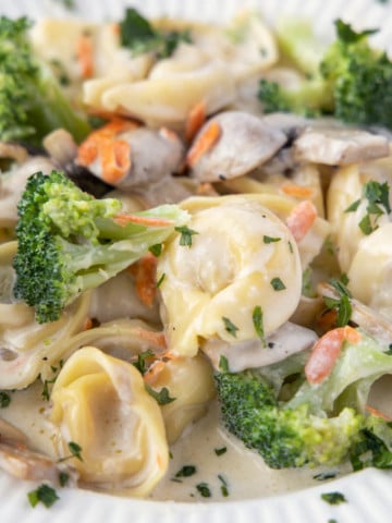 tortellini and broccoli in a white bowl