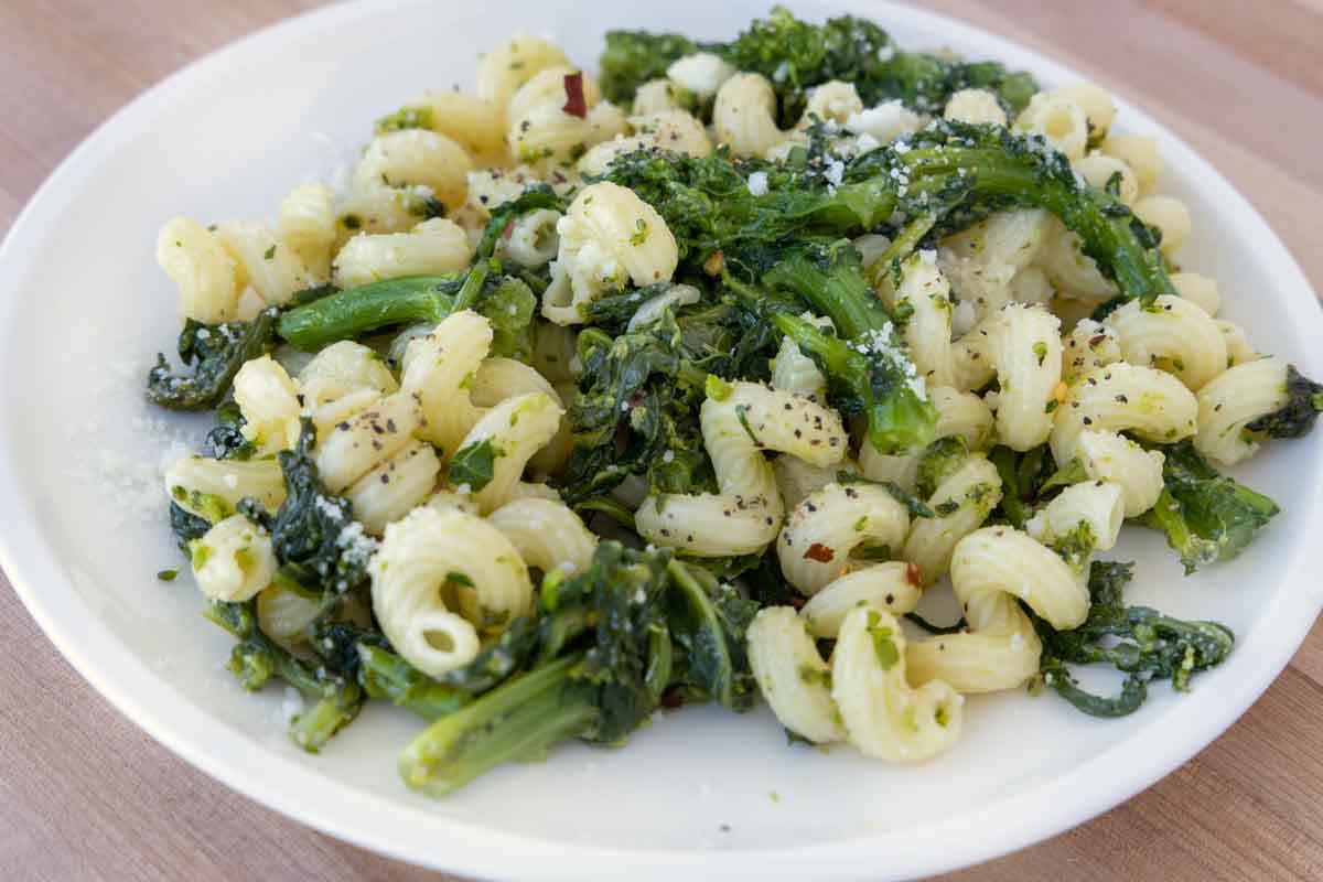 close up of Pasta Aglio e Olio with Broccoli Rabe on a white plate.