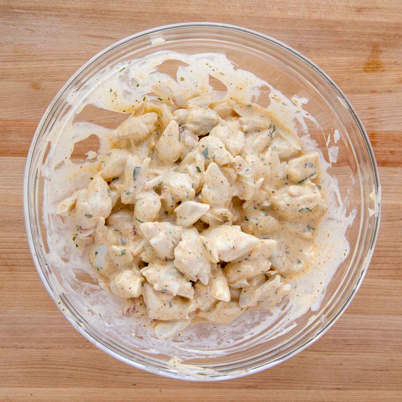 jumbo lump crabmeat mixed with imperial sauce in a glass bowl