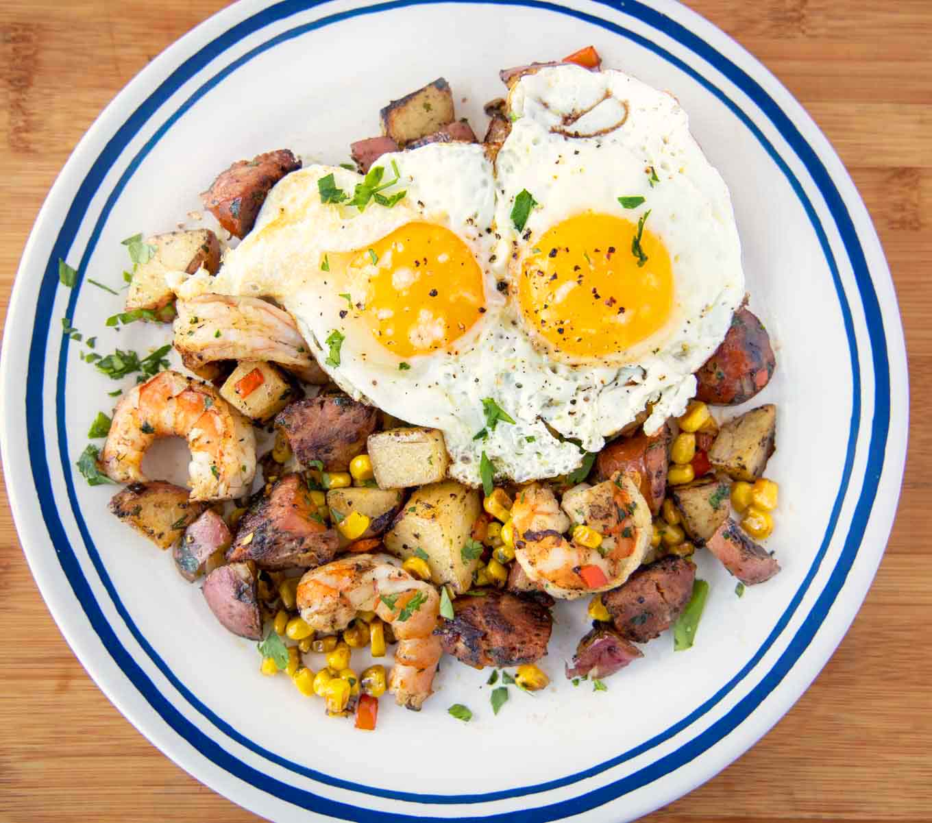 overhead shot of low country breakfast on a blue rimmed white plate