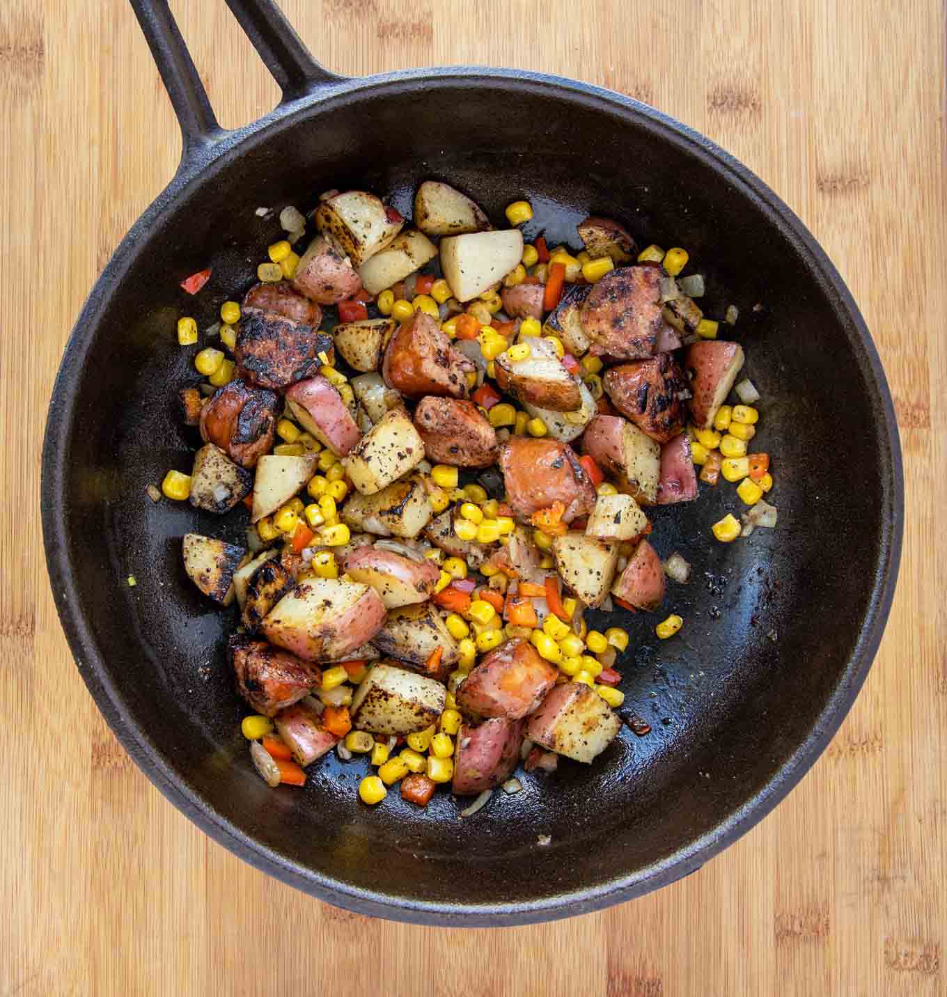 cast iron pan with corn added to the pan of other ingredients