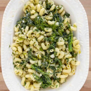 overhead shot of pasta aioli with broccoli rabe in a white oval bowl