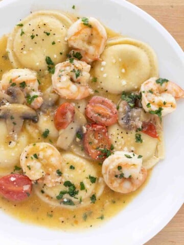 overhead view of ravioli shrimp scampi on a white plate