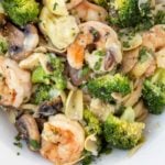 Shrimp and broccoli over linguine in a white bowl