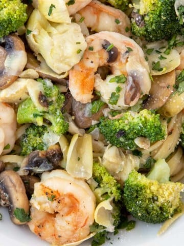 Shrimp and broccoli over linguine in a white bowl