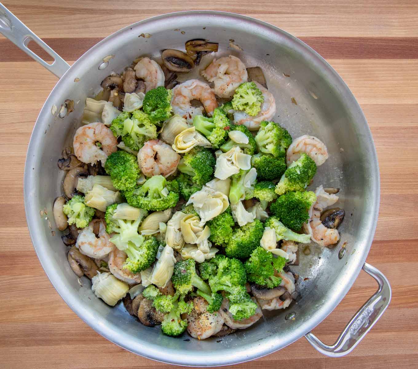 saute pan with mushrooms, shrimp, broccoli and artichoke hearts