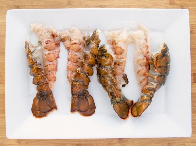 split lobster tails on a white platter