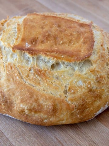 loaf of homemade artisan bread on a wooden cutting board