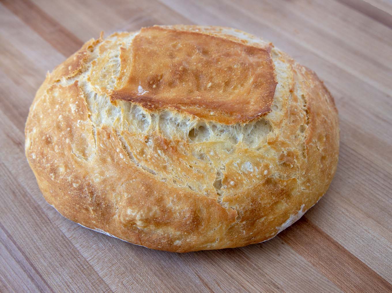 loaf of homemade artisan bread on a wooden cutting board