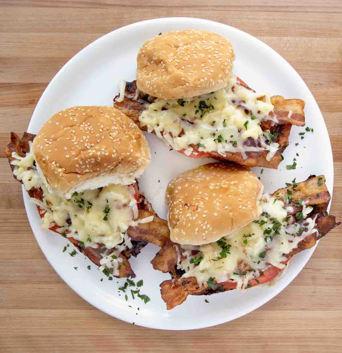 three grilled chicken sandwiches on a white plate