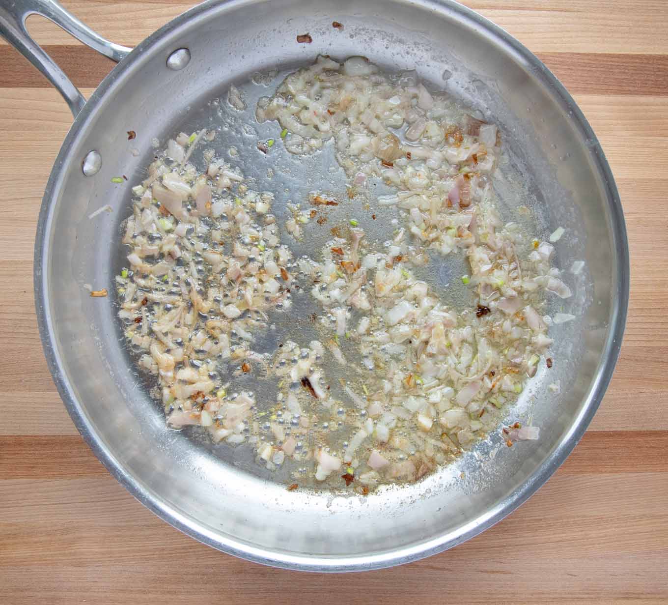 finely chopped shallots browning in a large saute pan