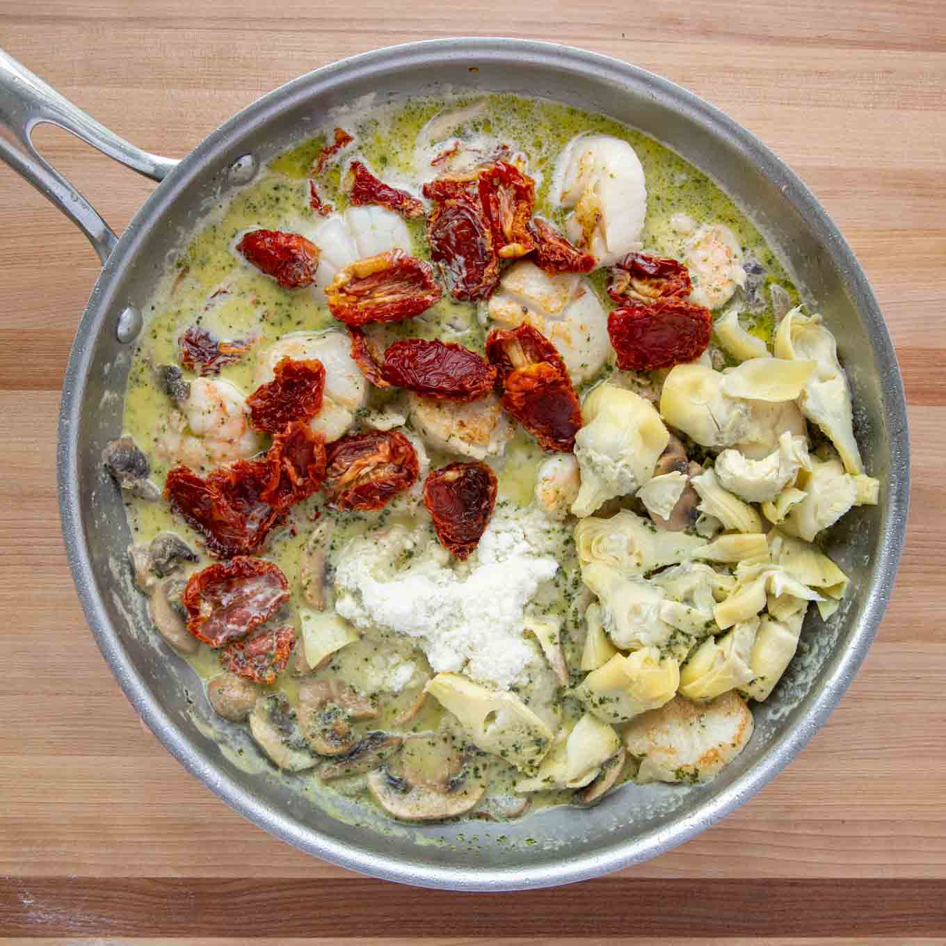 saute pan with sundried tomatoes, sliced artichoke hearts and Romano cheese added to the sauce