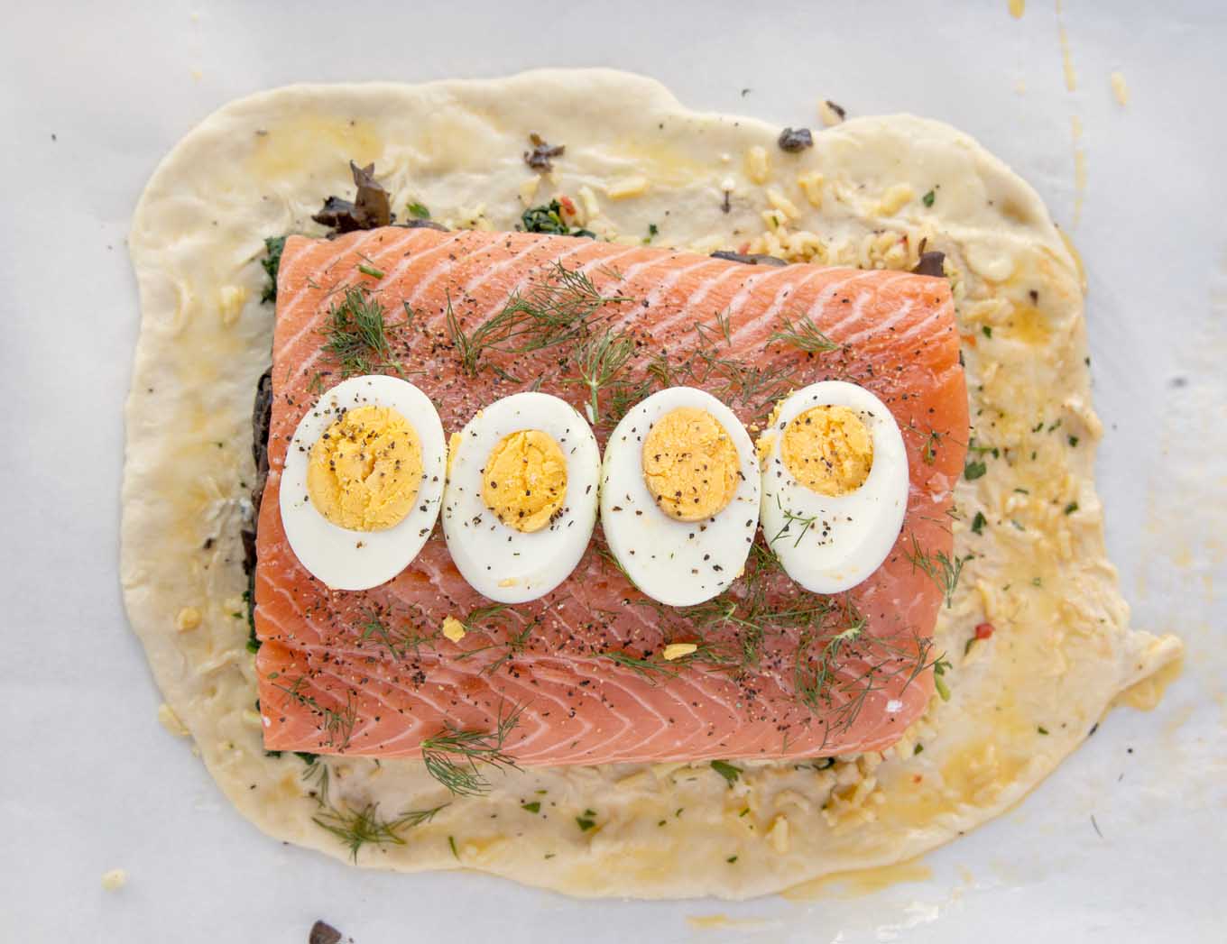 slices of hard cooked egg on top of the seasoned salmon layer of the Coulibiac of Salmon