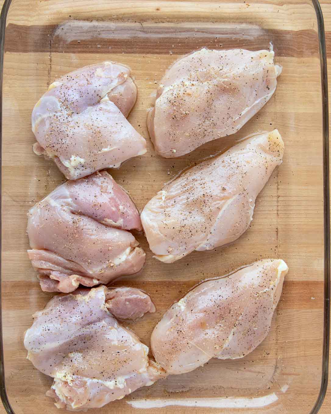 3 boneless skinless chicken breasts and 3 boneless skinless chicken thighs season with salt and pepper in a glass baking dish