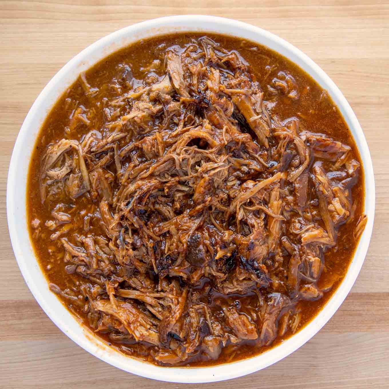white bowl of pulled pork in barbecue sauce