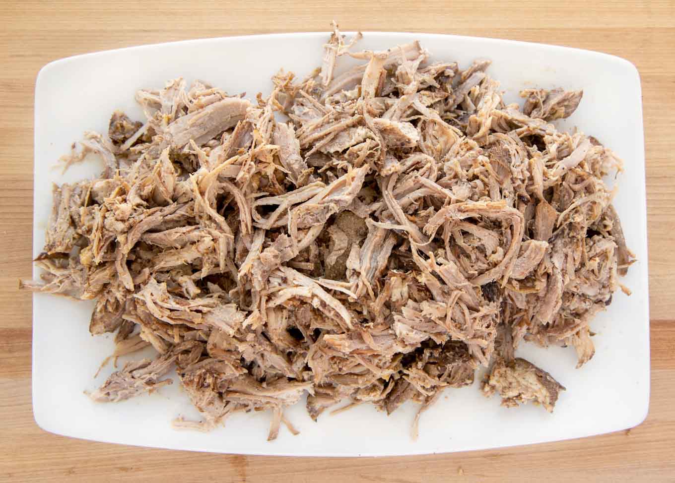 mound of pulled pork on a white platter