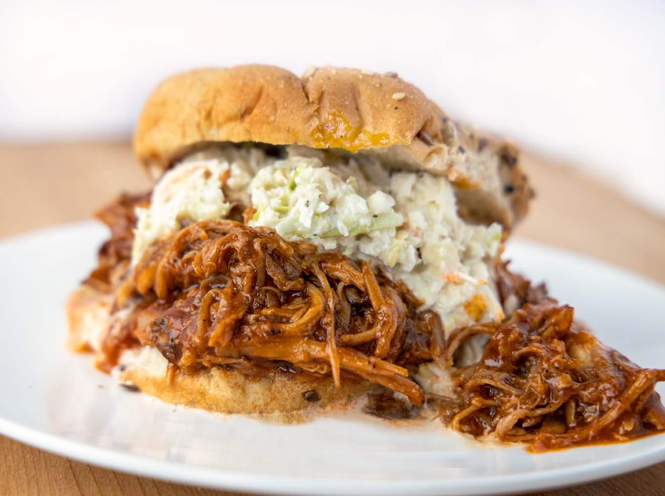 pulled pork topped with cole slaw on  seeded multigrain hamburger roll