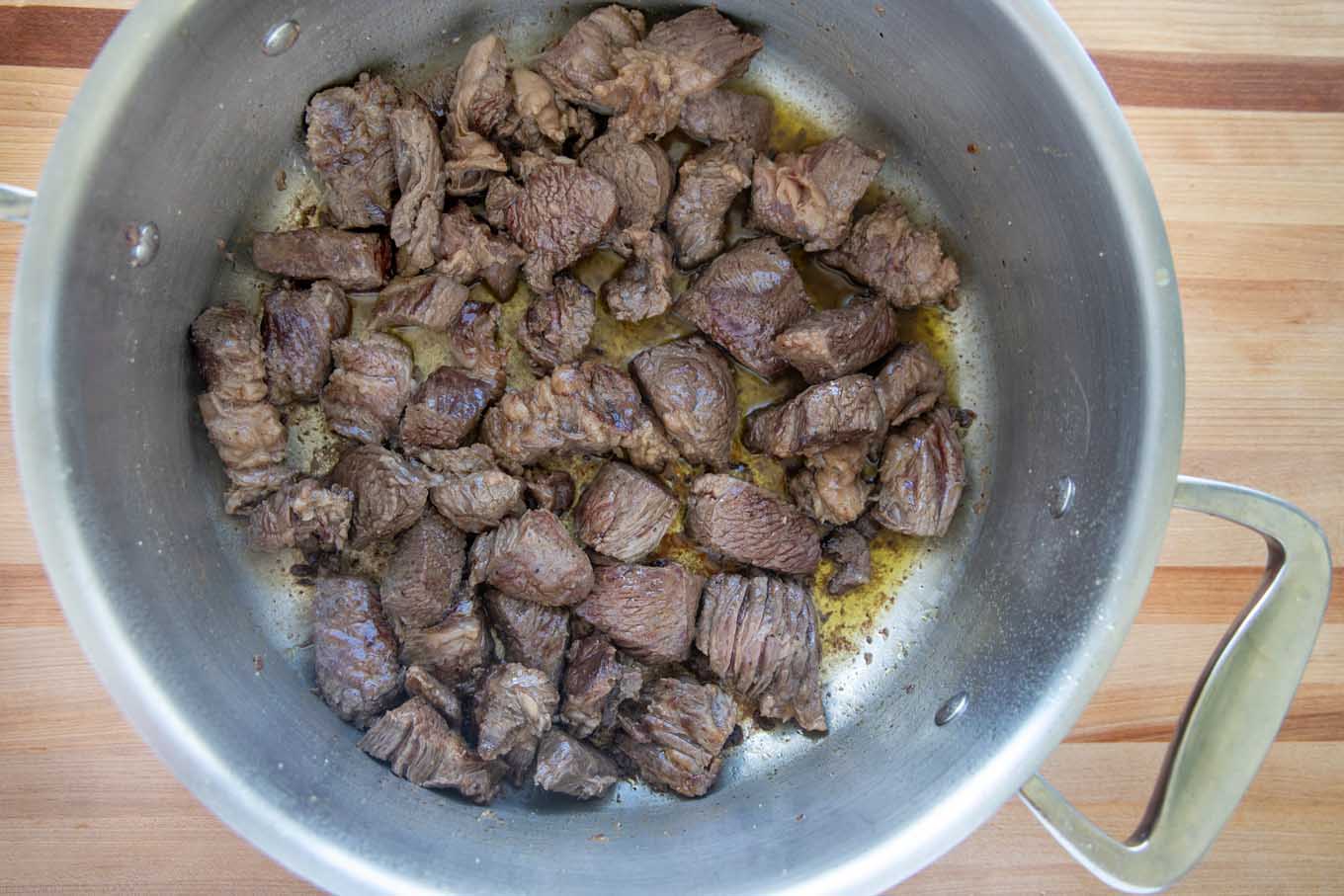 beef chunks browning in a large pot