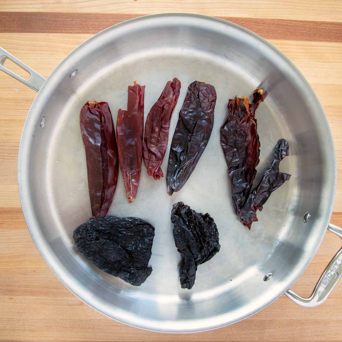 chili peppers toasting in a large saute pan 