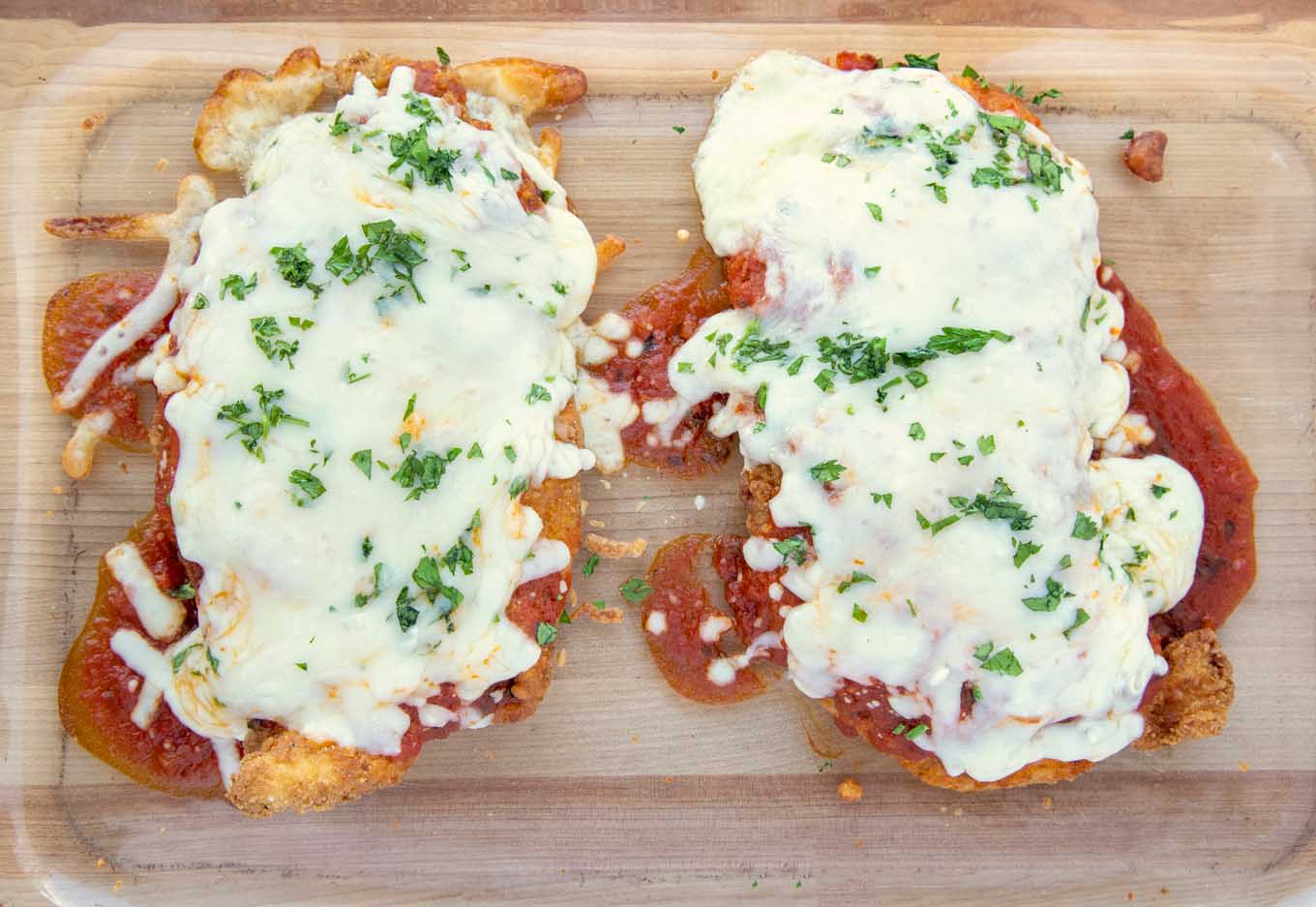 Cooked chicken parm in a glass baking dish.