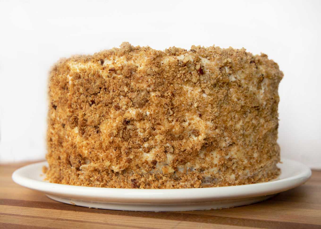 four layer banana crunch cake frosted and coated with crunch topping