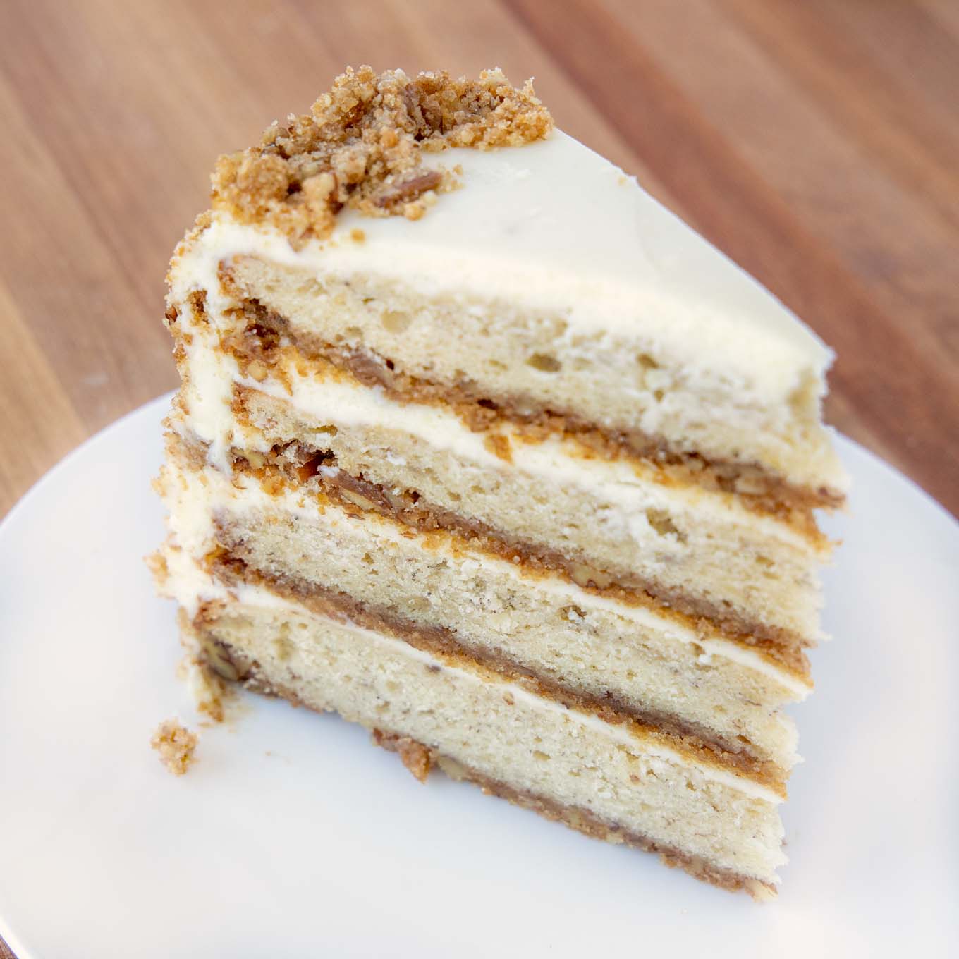slice of four layer banana crunch cake on a white plate