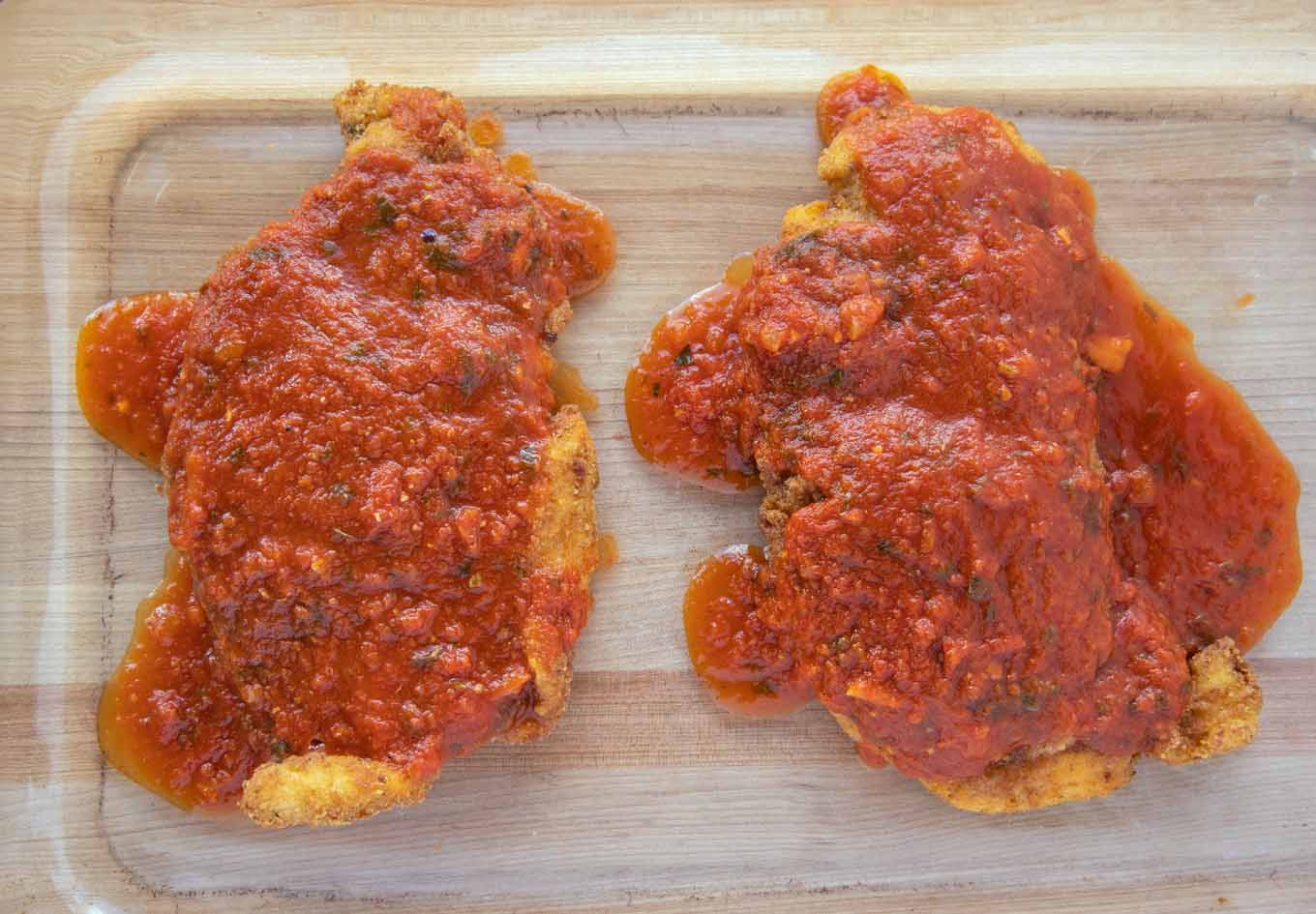 Fried chicken cutlets topped with tomato sauce.