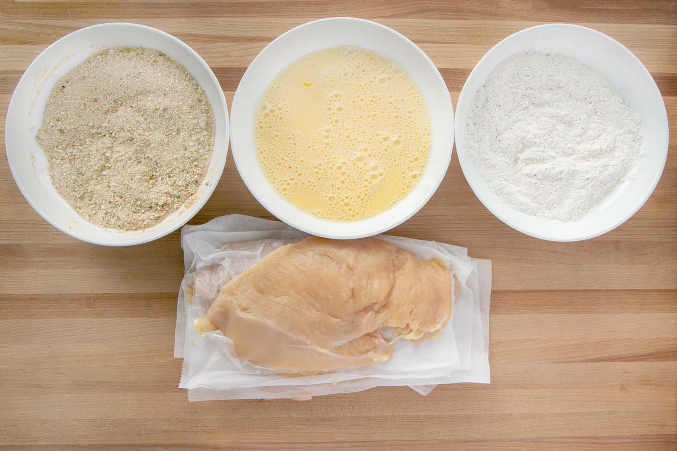Ingredients to make a breaded chicken cutlet.
