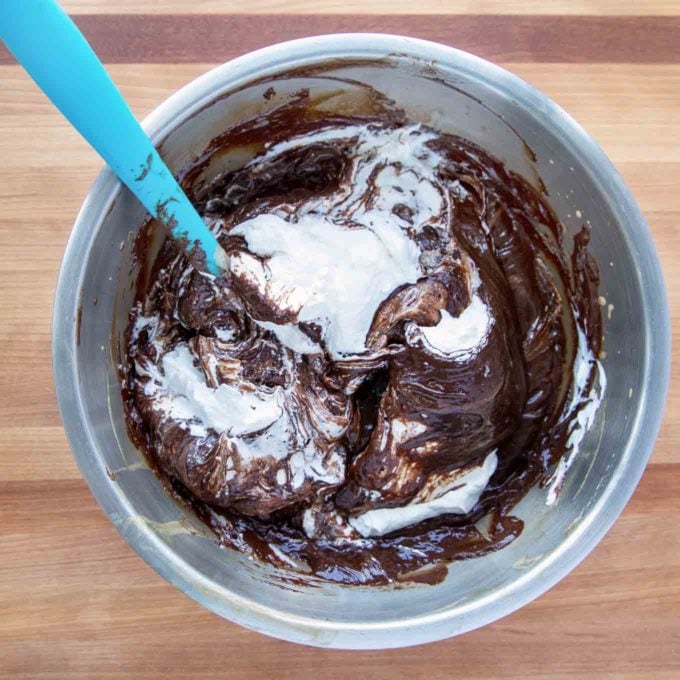 mixer bowl with whipped cream folding into chocolate mixture