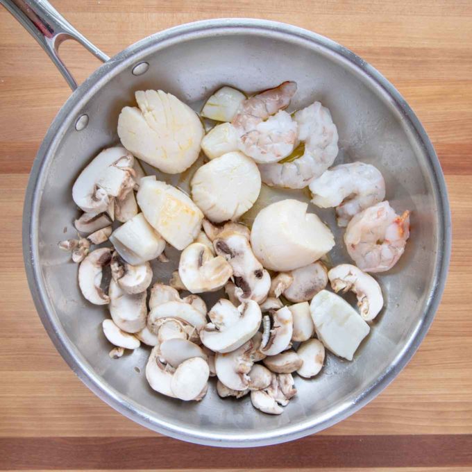 shrimp, scallops and mushrooms in a saute pan