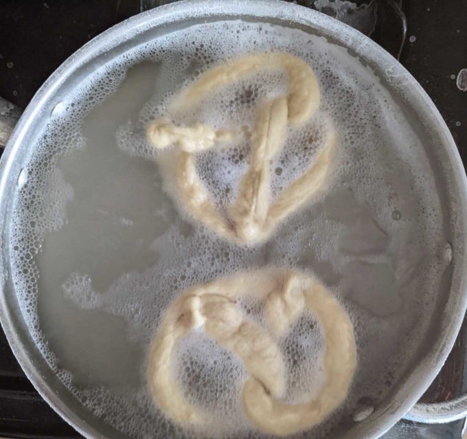 to pretzels in a pot of boiling water 