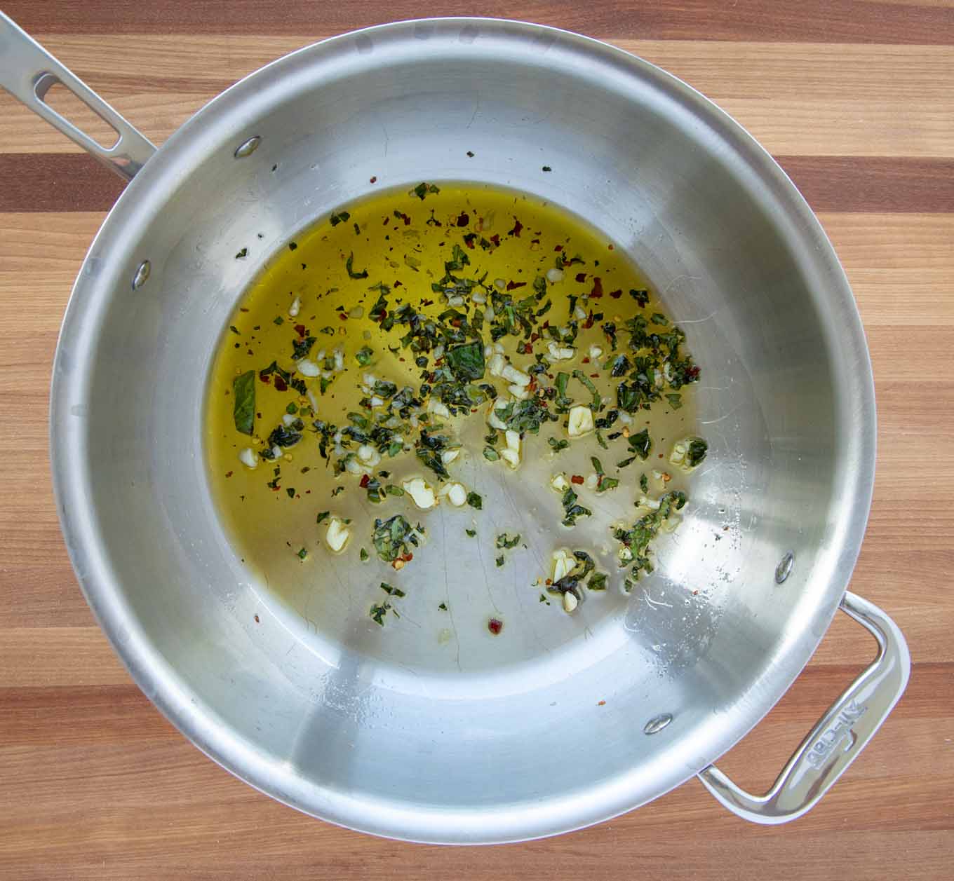 garlic and spices with olive oil in a large saute pan