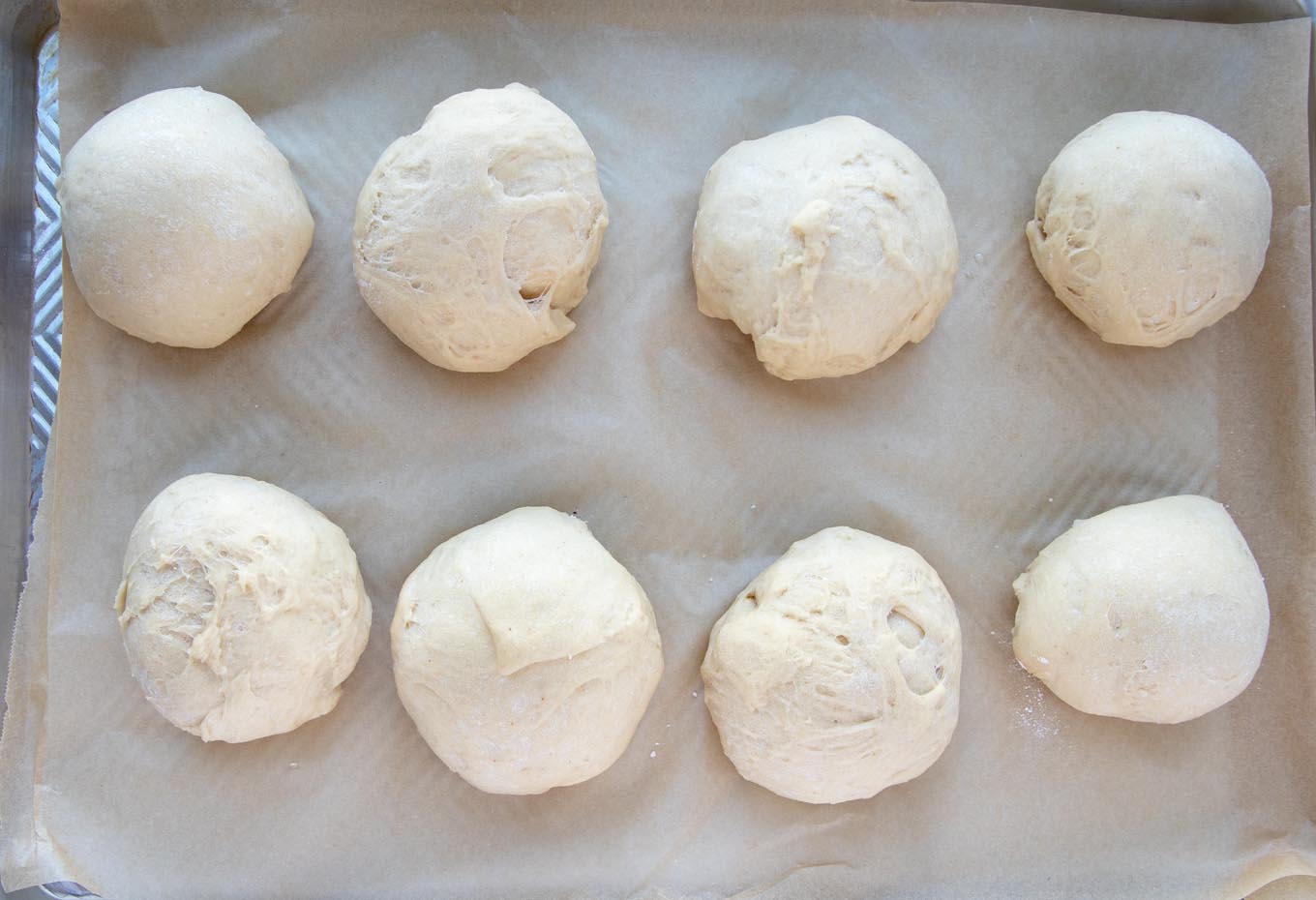 dough balls on parchment paper on baking sheet