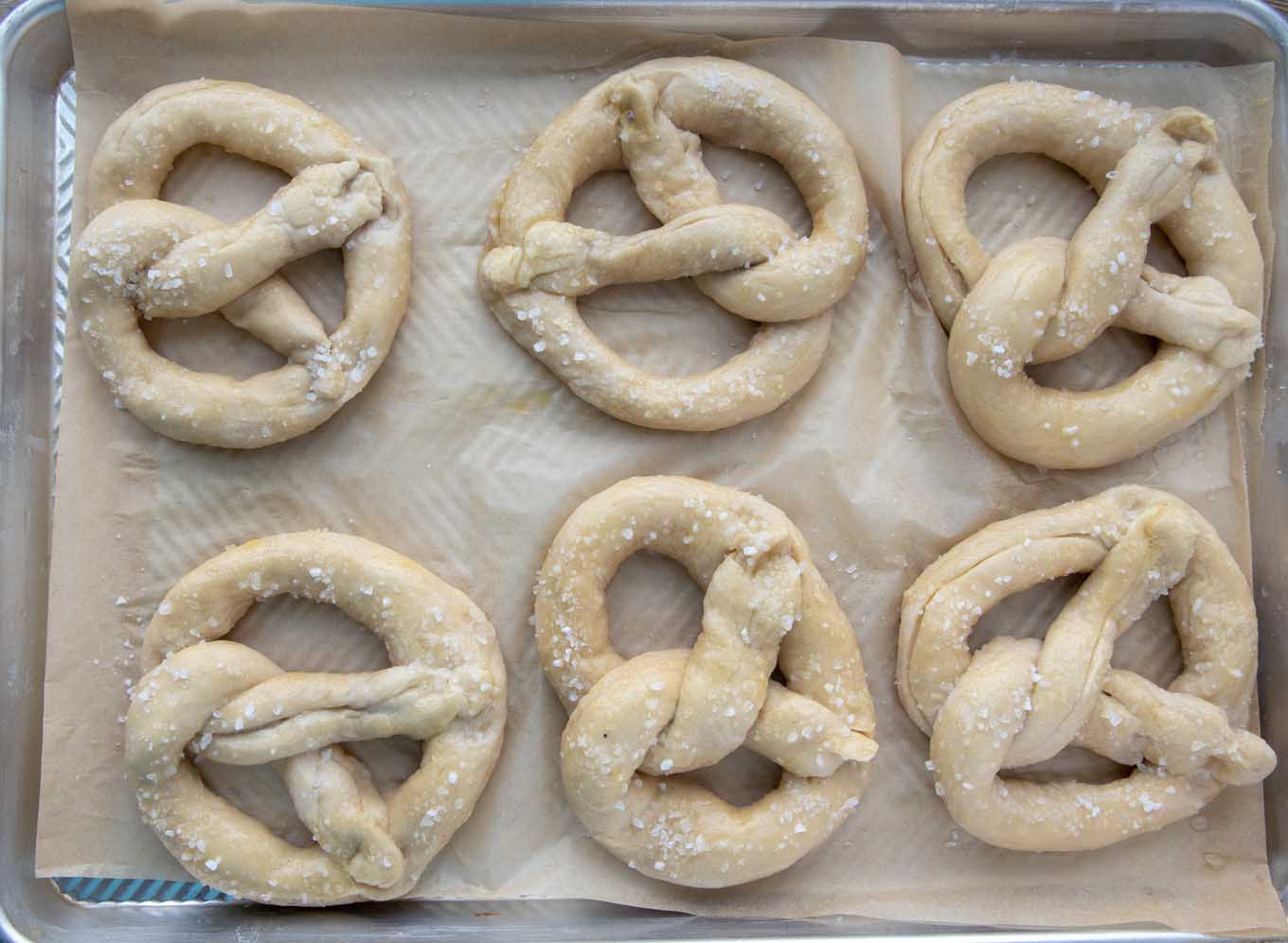 salted raw beer pretzels on a baking sheet