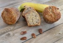 banana pecan muffins with bananas in the background