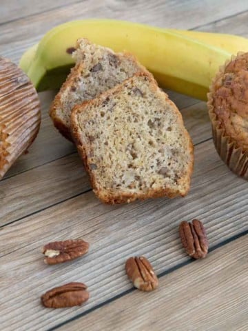 banana pecan muffins with bananas in the background