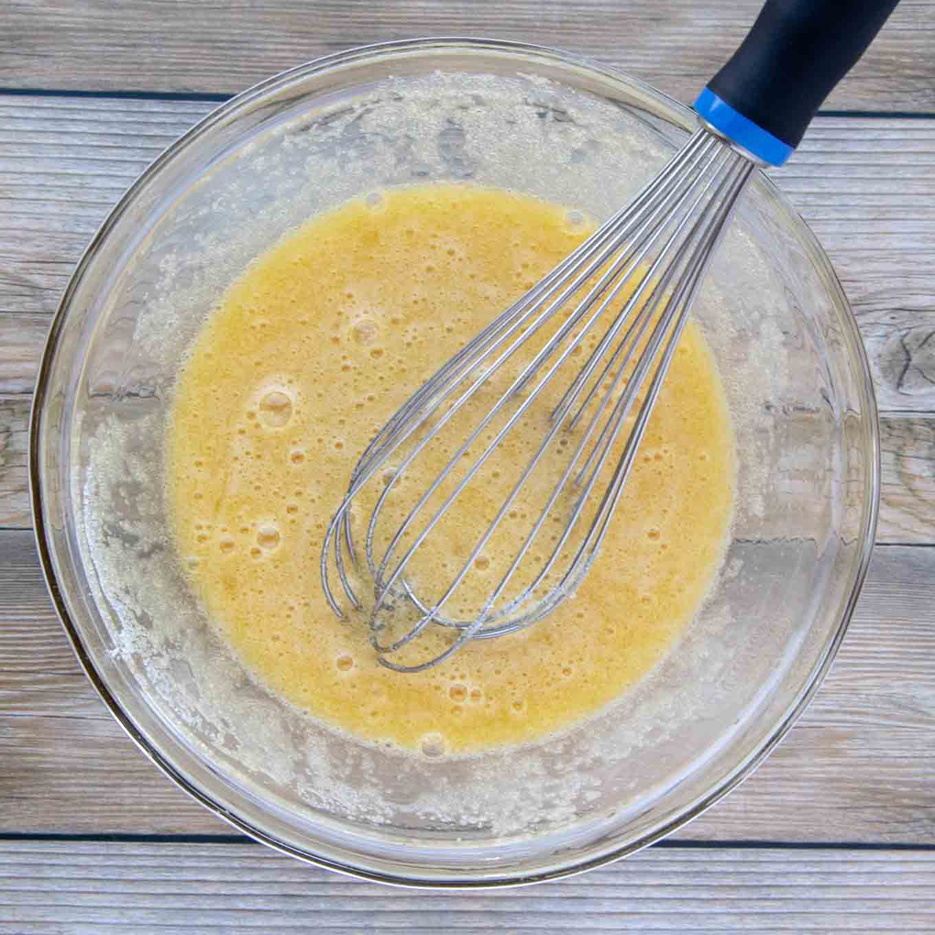 eggs mixed with sugar with a wire whisk in a glass bowl