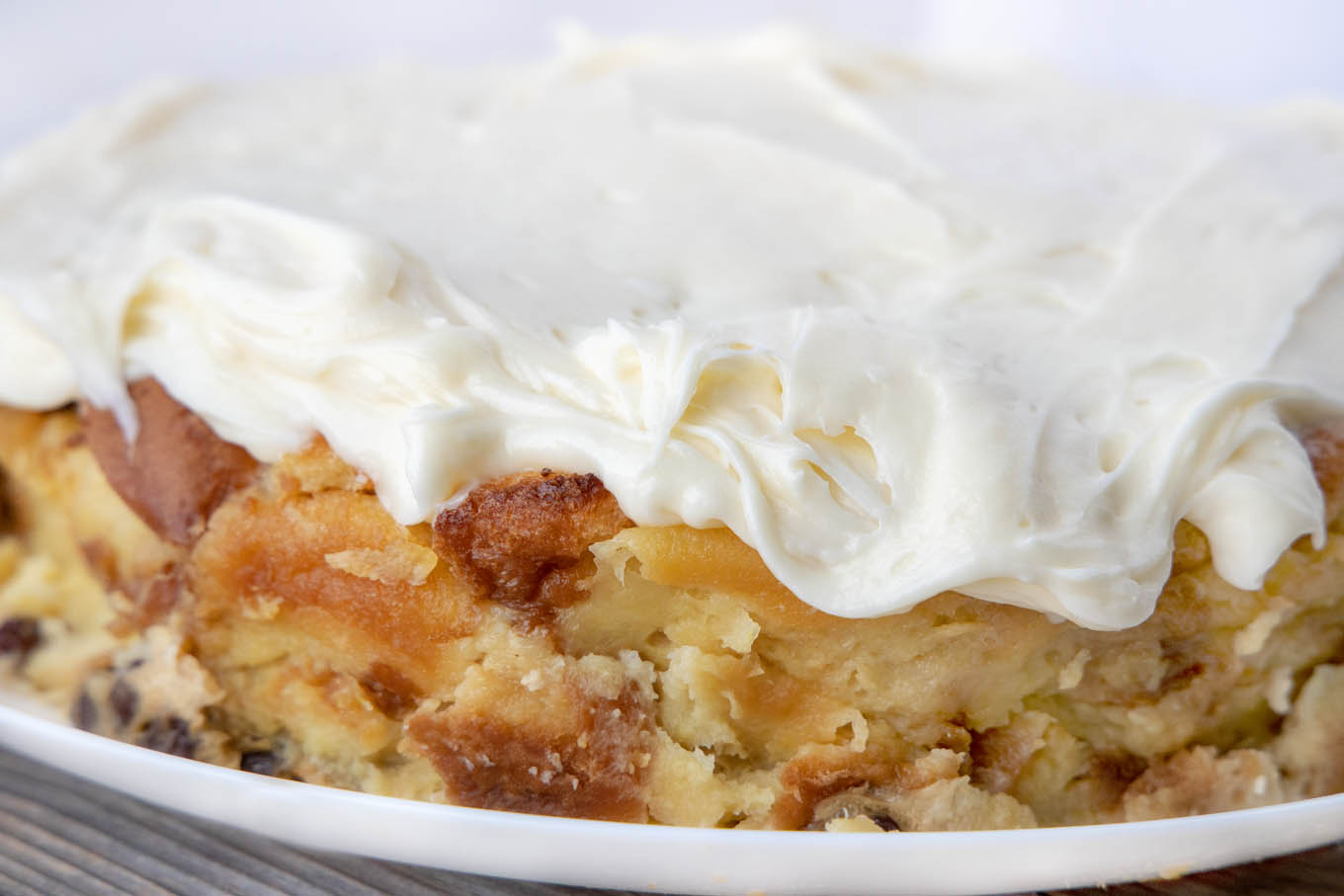 side view of bread pudding topped with cream cheese frosting