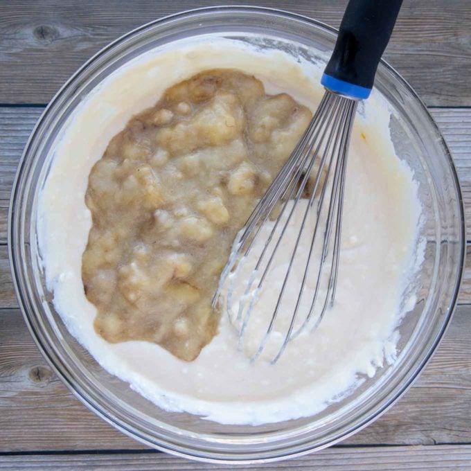 wet ingredients with mashed bananas added in with a wire whisk in the bowl