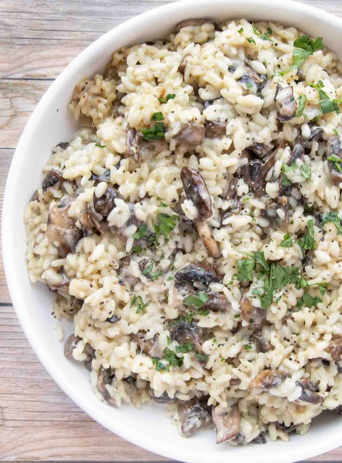 creamy mushroom risotto in a white bowl