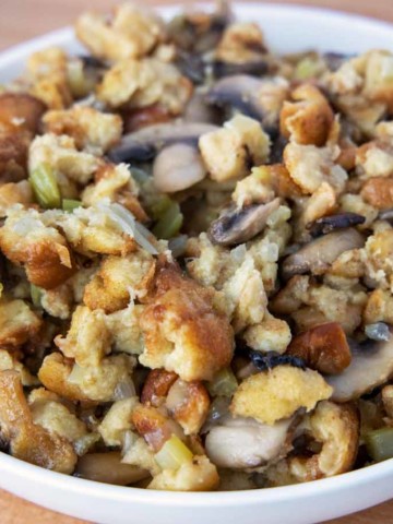 side view of white bowl of stuffing with spoon